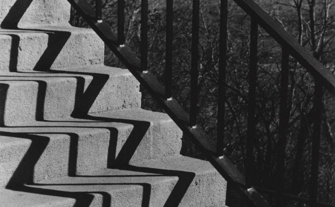 zigzag shadows cast on staircase from railing