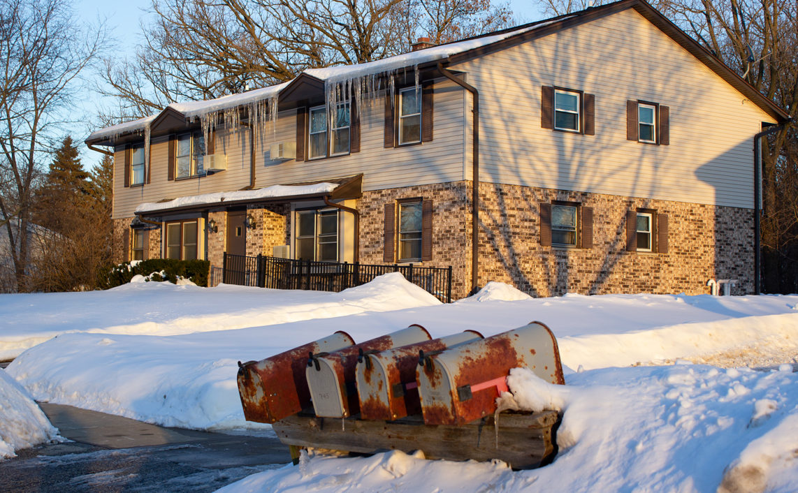 long icicles hang off roof of apartment building