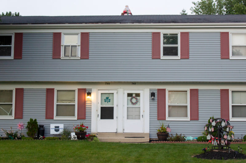 santa decoration on roof of house seen from street in summer